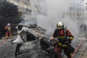 PARIS, FRANCE - DECEMBER 01: Cars are put on fire nearby the Arc de Triomphe, on December 1, 2018 in Paris, France. The demonstrators, known as "gilets jaunes" or "yellow vests," have protested across France for the last two weeks, demanding a reduction in fuel prices. French law requires drivers to carry yellow vests in case of accident. (Photo by Veronique de Viguerie/Getty Images)