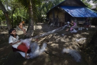 SITTWE, MYANMAR- JUNE, 2015: Bodouba camp.  A family is working in recycling fishnets. The baby is severely malnourished as many Rohingya babies. (Picture by Veronique de Viguerie/Reportage by getty Images).