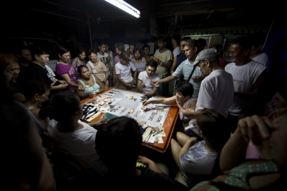 MANILA, PHILIPPINES - OCT, 2016: Neignbourgs are betting and playing cards in front of Flor John's house. The money made will help with the funeral services. Flor John (34), drug user, was executed by some apparent policemen at his house on the 19th of October. He was the father of three and married with Rita Cruz.  (Picture by Veronique de Viguerie/ Reportage by Getty Images).