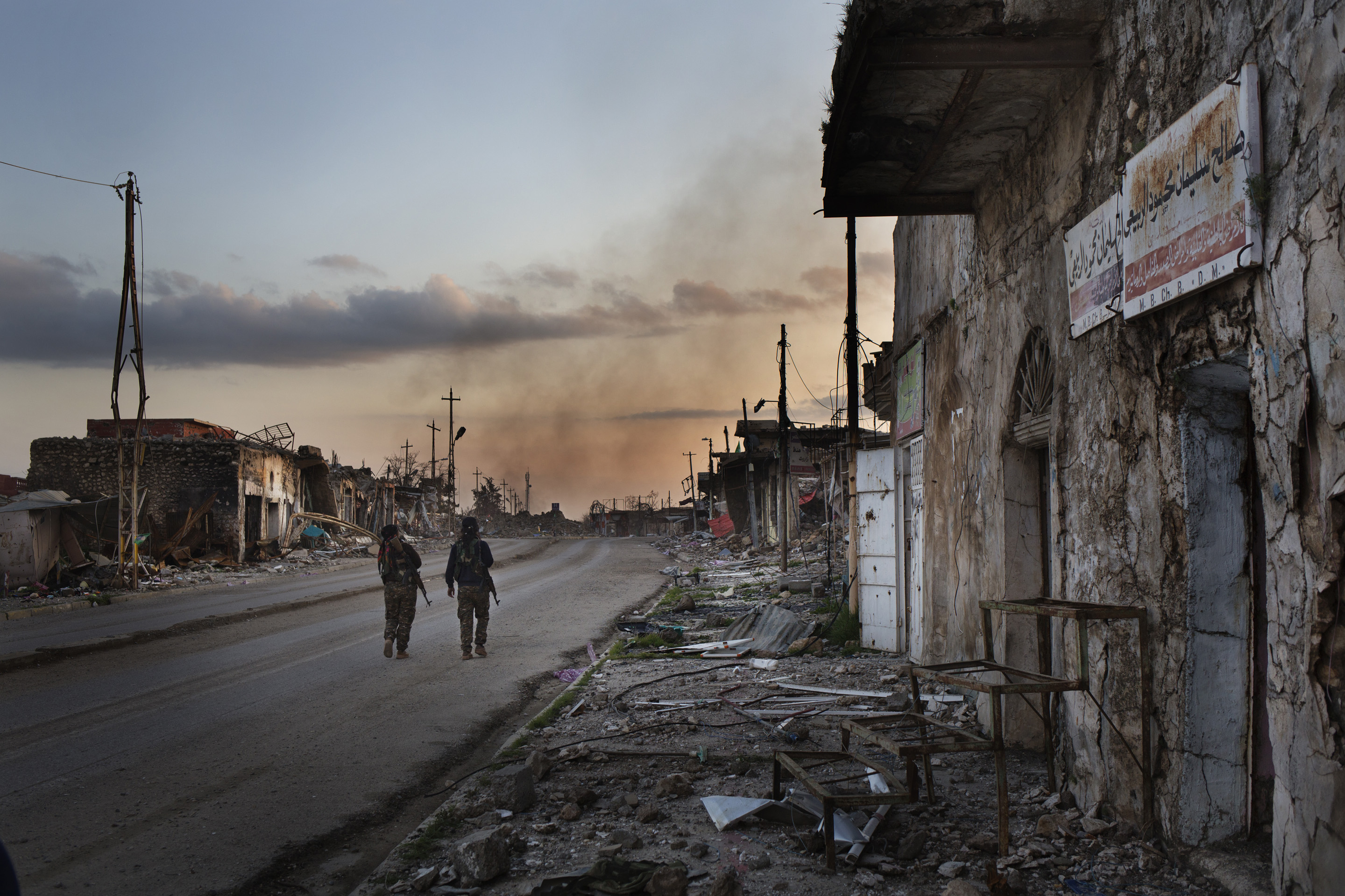 SINJAR, KURDISTAN, IRAQ- FEBRUARY, 2016: Shilan (casquette) Yezidie combattante du YBS marchent avec sa camarade dans les ruines de la ville martyr de Sinjar. Des obus et des mortiers de Daech continuent de tomber. (picture by Veronique de Viguerie/ Reportage by Getty Images )