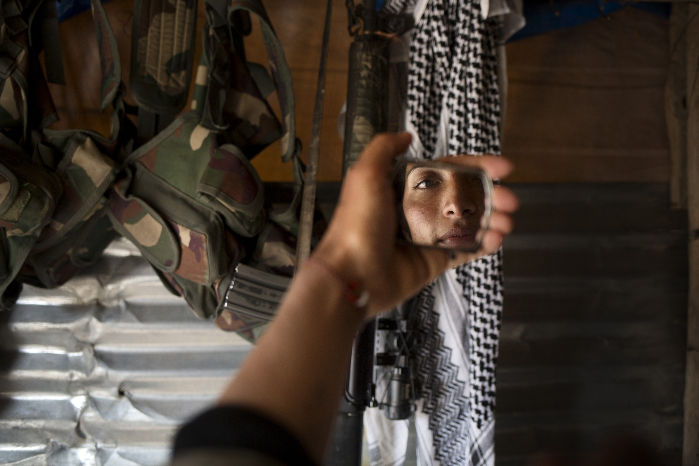 SINJAR, KURDISTAN, IRAQ- FEBRUARY, 2016: Norouz (21) se recoiffe devant un fusil d'assault pris Ã  un membre de Daesh tuÃ© par ses camarades il y a quelques jours.(picture by Veronique de Viguerie/ Reportage by Getty Images )